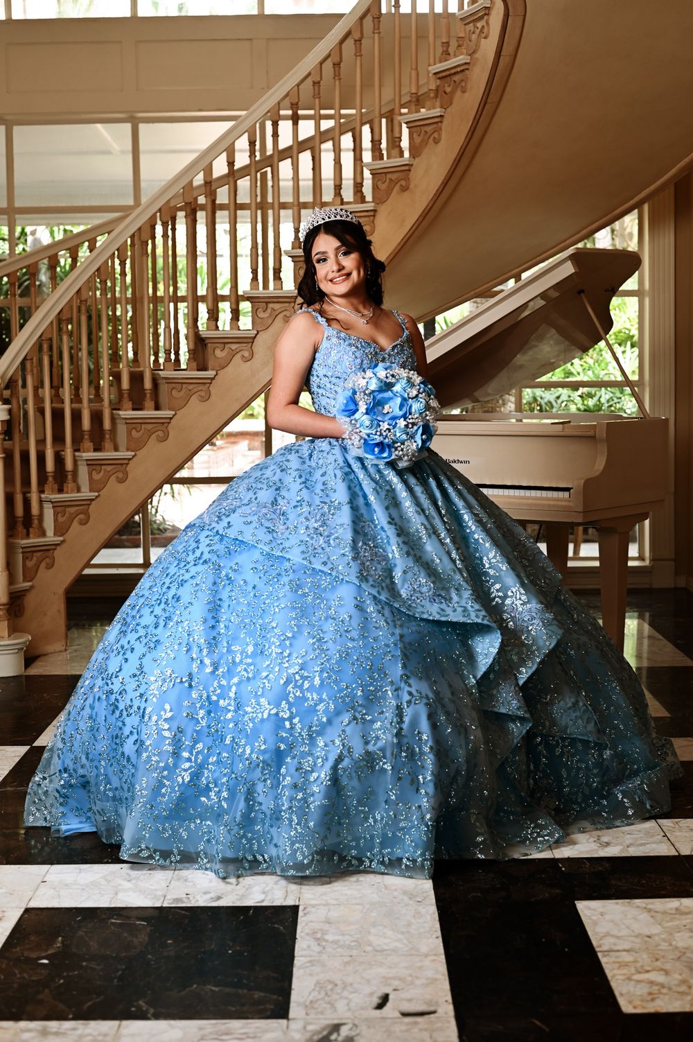 Elaborate light blue ball gown with sequins and lace photographed in an elegant foyer.