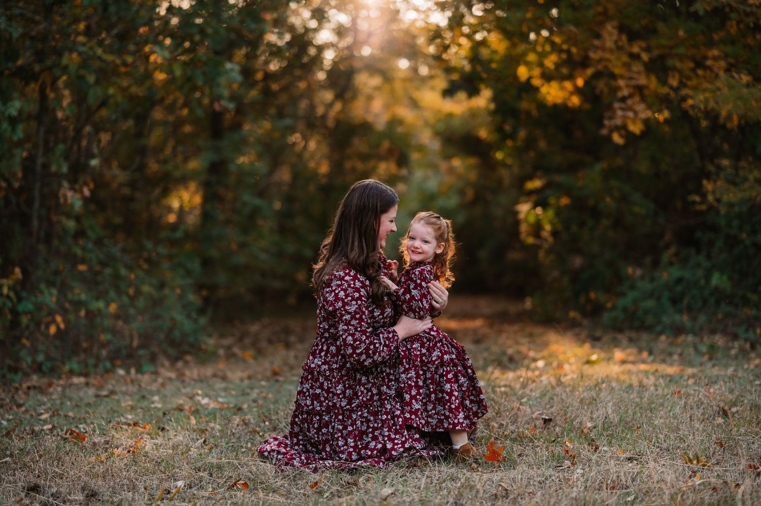 Mother looks adoringly at preschool aged daughter during dallas area outdoor fall family photo session at sunset by mesquite photographer