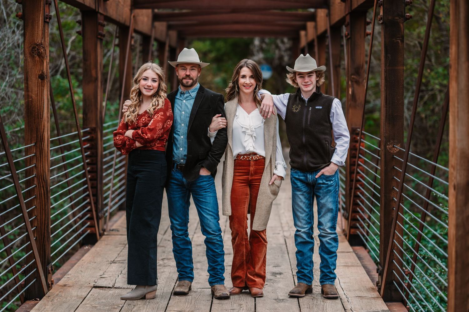 Family of 4 poses on bridge during dallas area outdoor fall family mini photo session