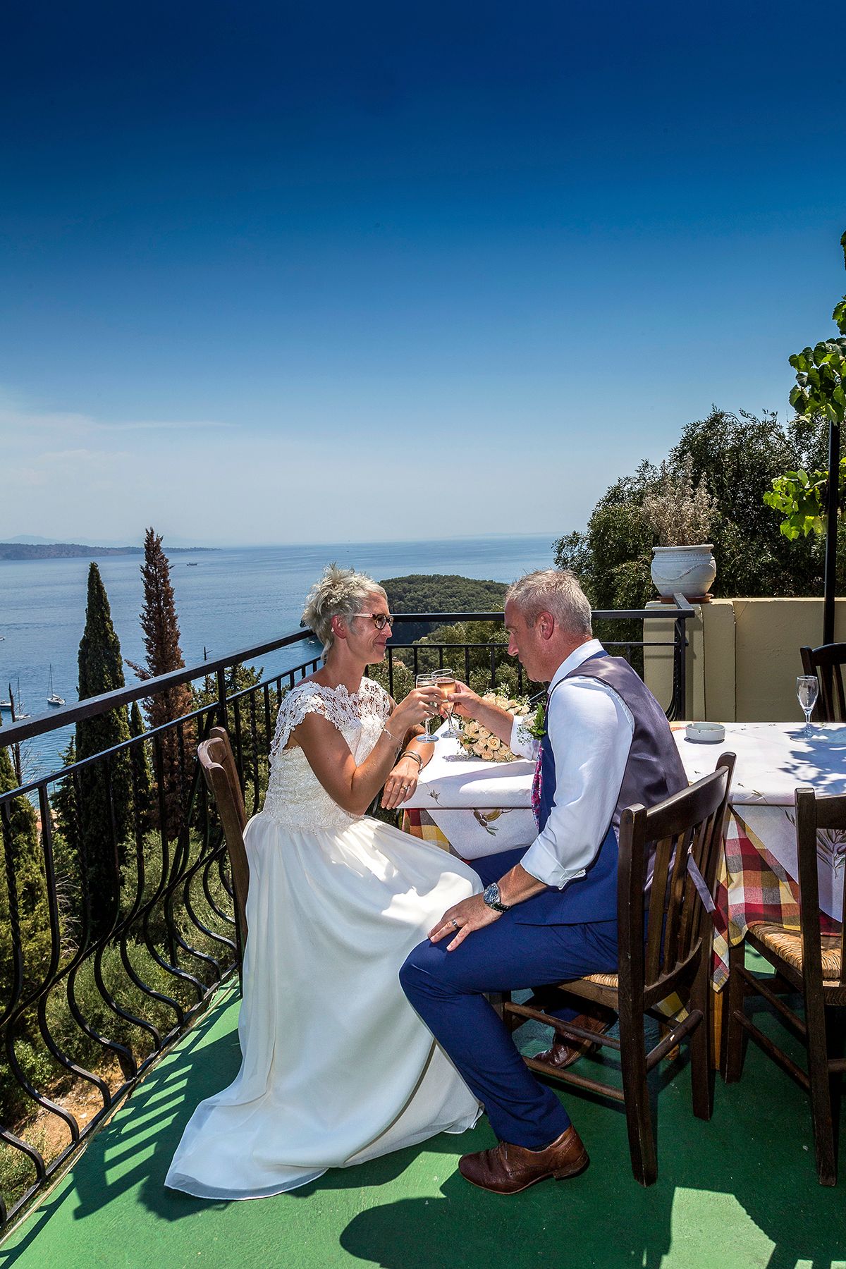bride and groom having drinks overlooking thr sea at corfu