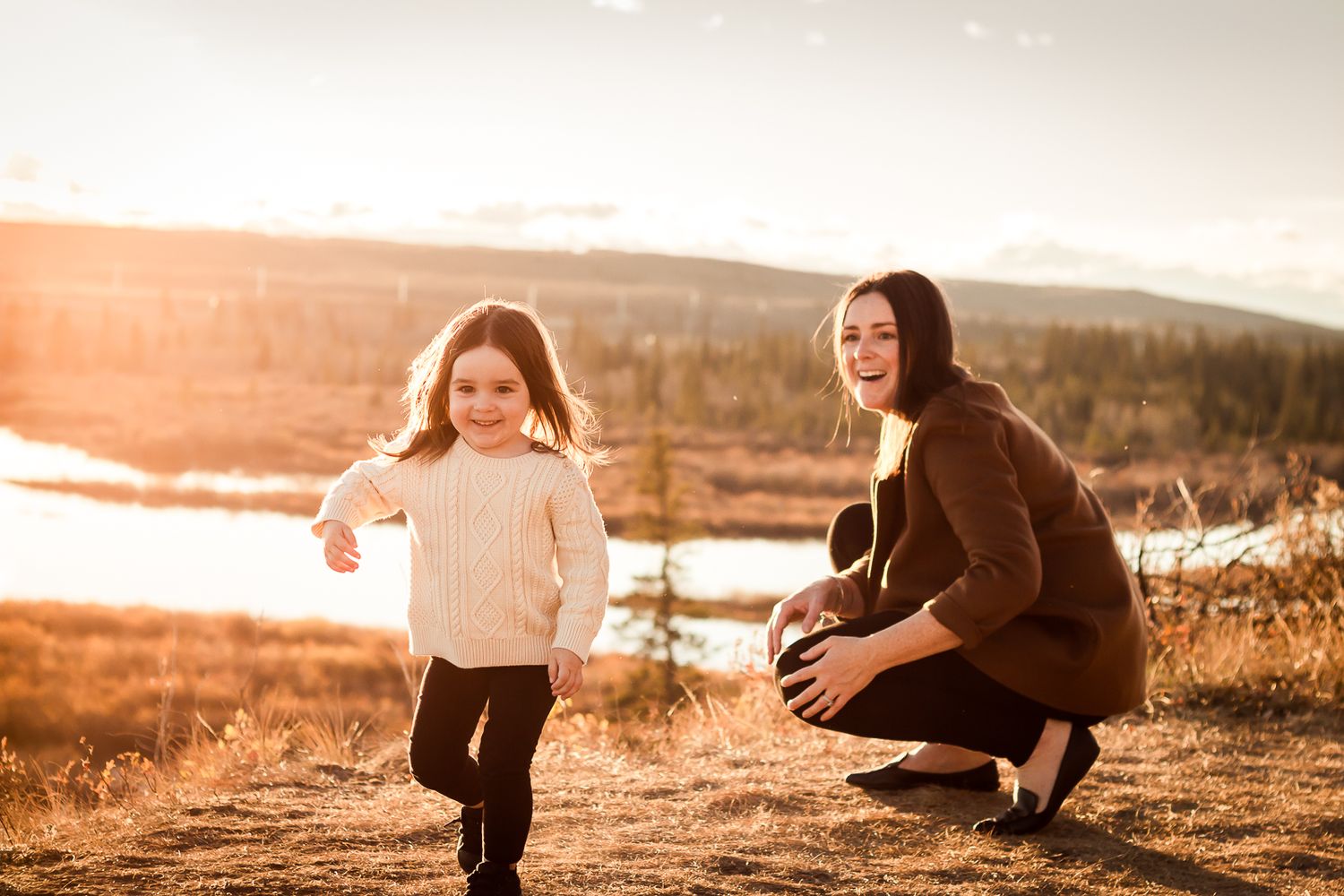Beautiful mother daughter moment during fall family photos at golden hour in Glenmore Reservoir.