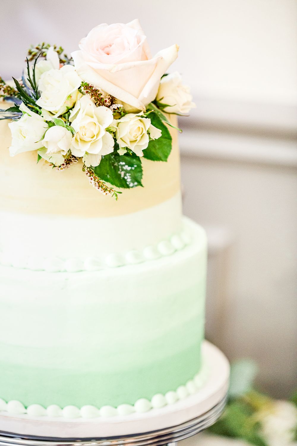 An elegant mint ombre wedding cake decorated with fresh pink and white roses by Stephanie Coulter Photography