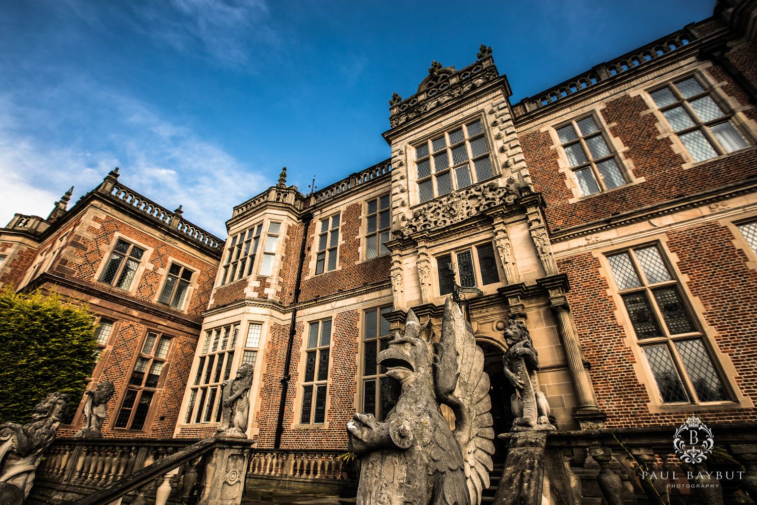 Gothic revival architecture of historic mansion with ornate stone details against blue sky.