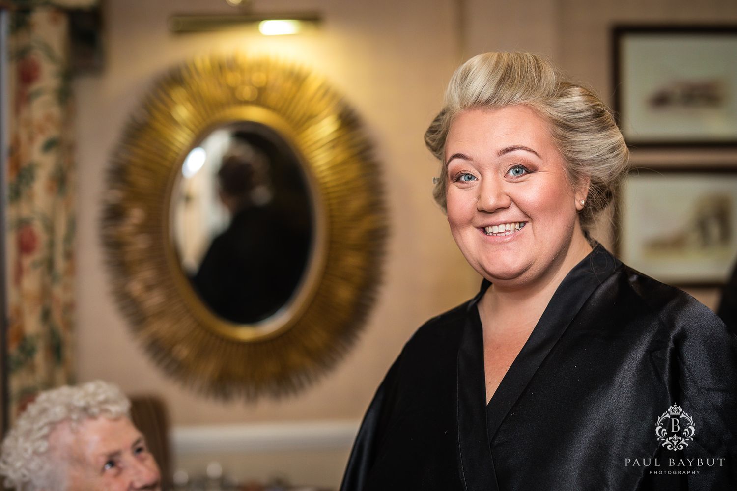 A joyful moment captured in front of a decorative gold mirror with a black robe ensemble.