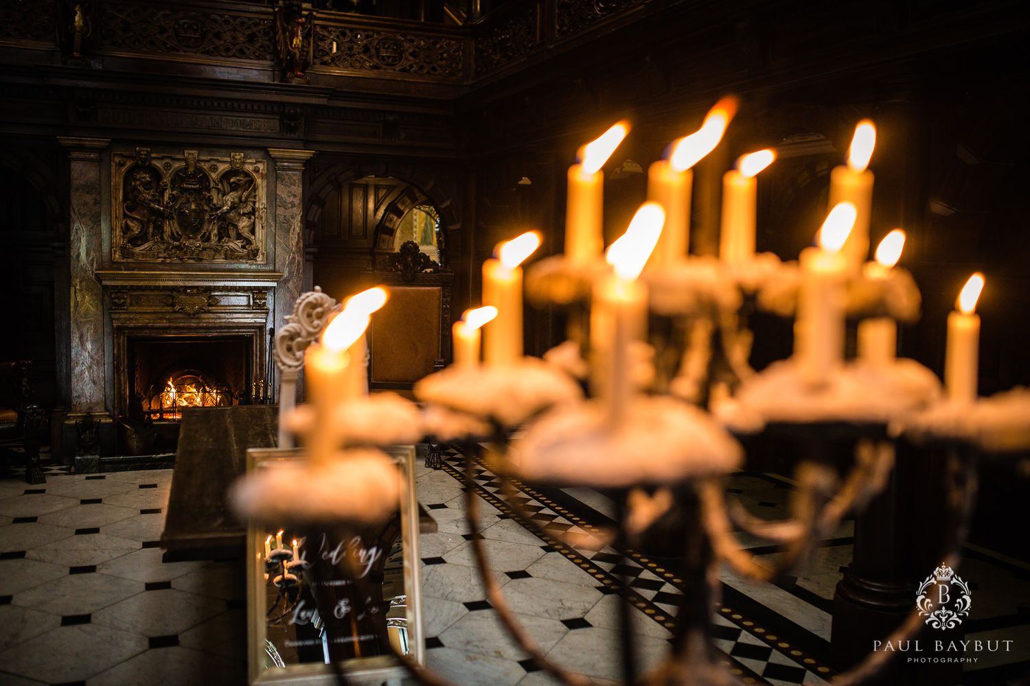 Elegant candlelit room with ornate fireplace and glowing candelabra creating romantic ambiance.