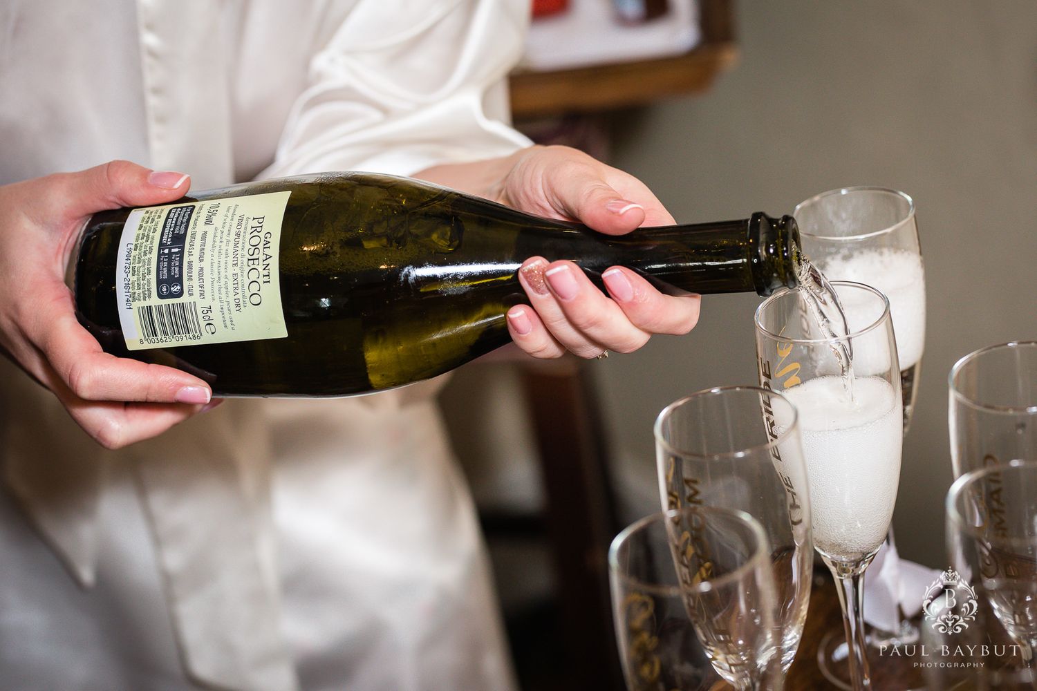 Hands pouring champagne into glasses during a celebration event.