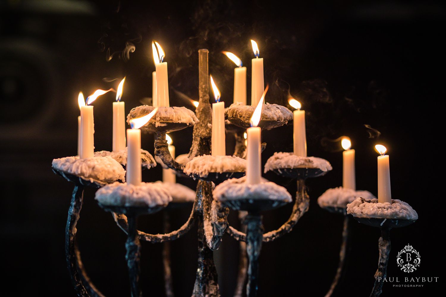 Antique candelabra with lit candles creating a dramatic atmosphere in dark setting.