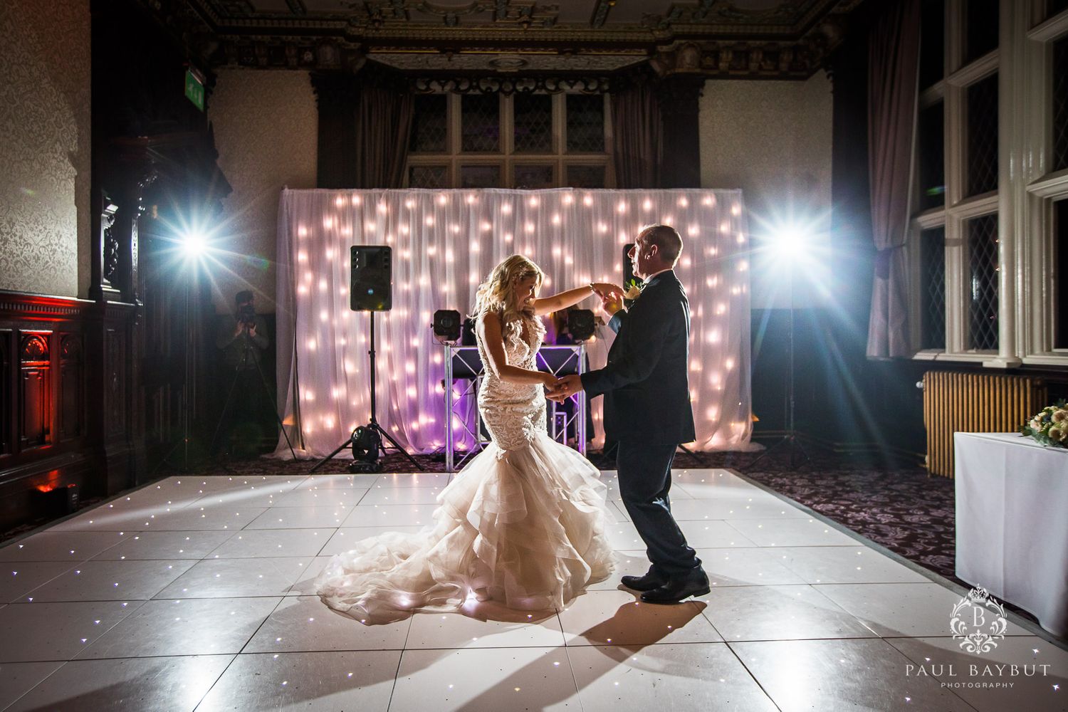 Couple performs romantic dance moves under dramatic lighting at their wedding reception.