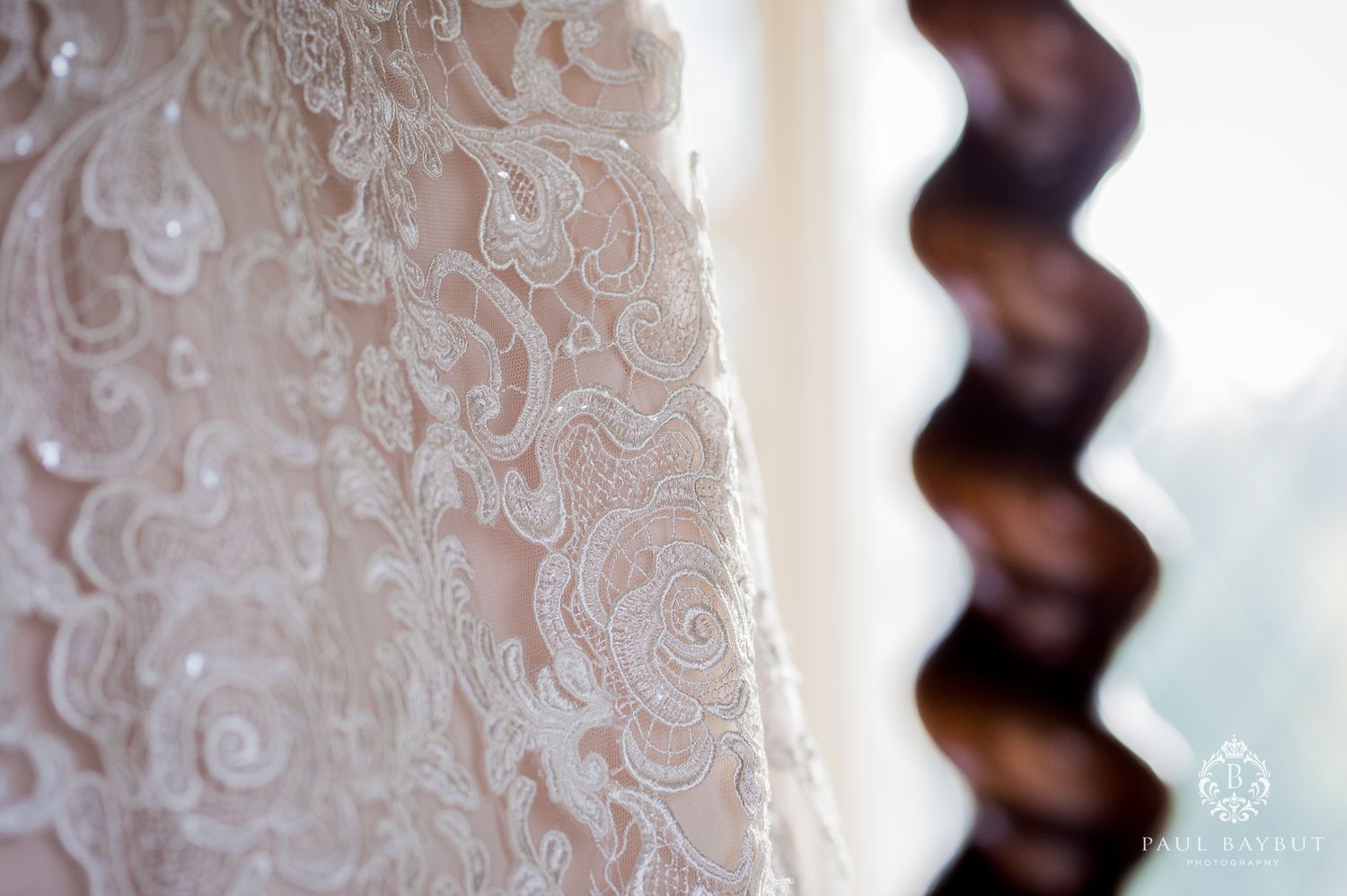 Close-up detail of delicate lace patterns on a white wedding dress fabric.