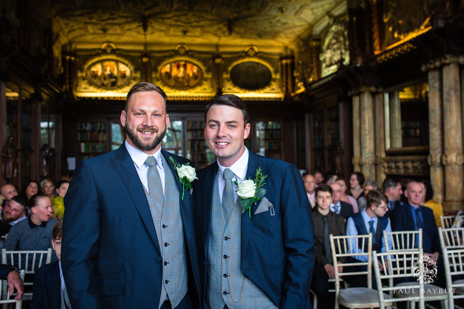 Wedding ceremony setting in an ornate historic venue with decorative ceiling.