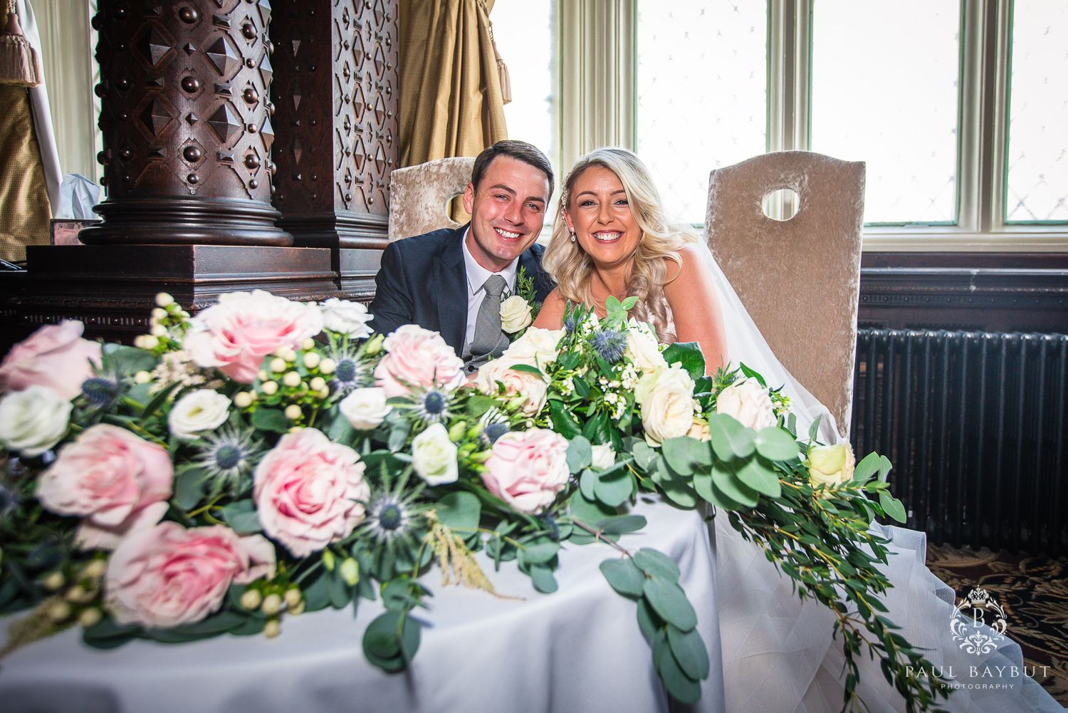 Beautiful floral arrangements with pink roses decorate the wedding reception table.