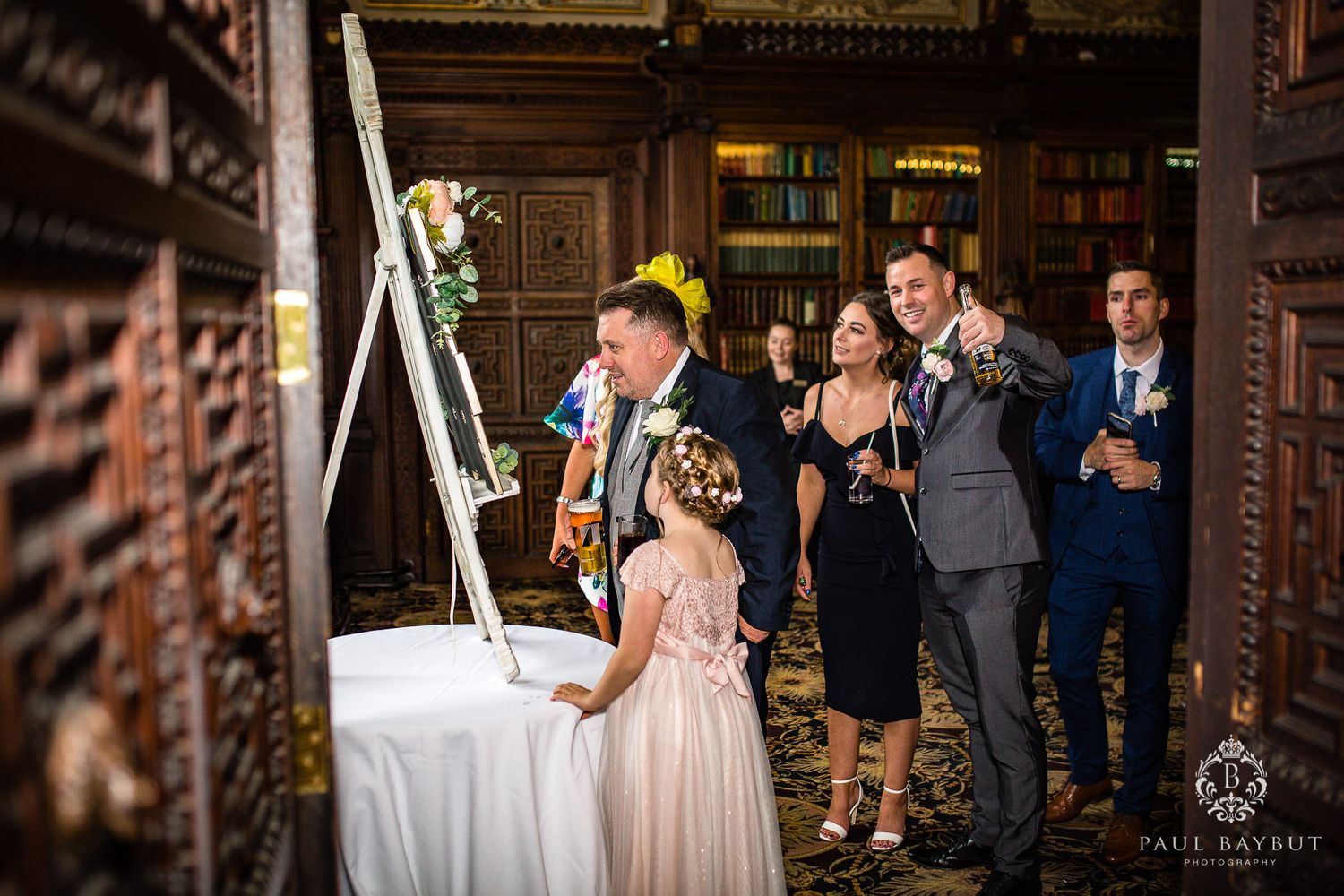 Wedding guests gather around a display board during the reception.