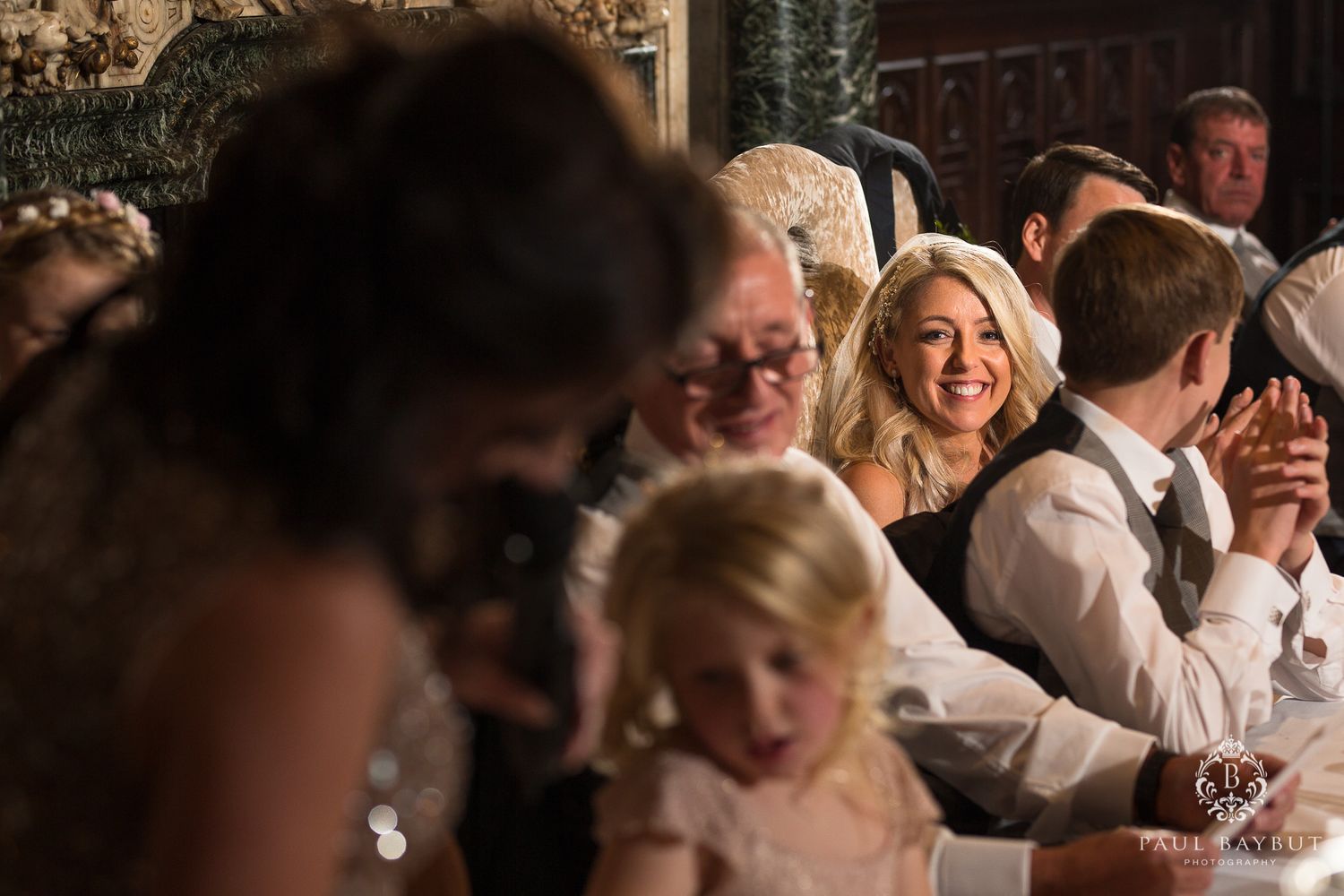 Candid moment of wedding guests laughing and enjoying themselves at a formal reception.