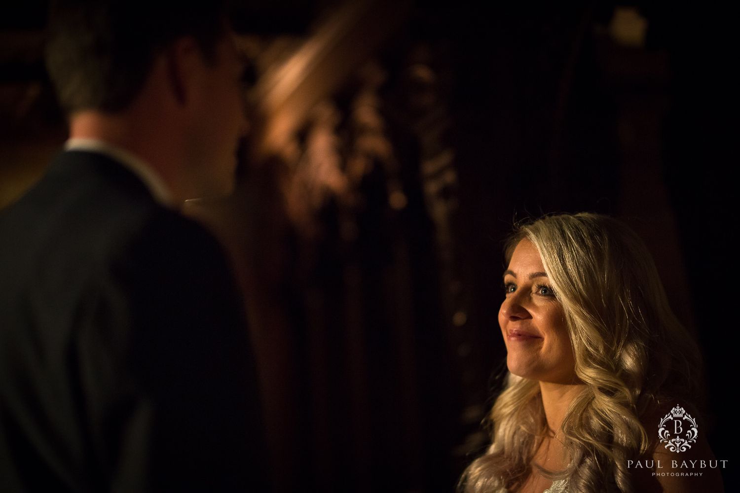 Intimate moment captured in dramatic low lighting with warm tones.
