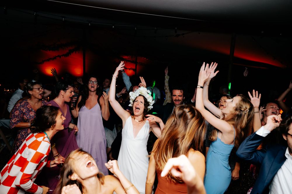 Crowd enjoying themselves on a dance floor with dramatic red and blue lighting effects.