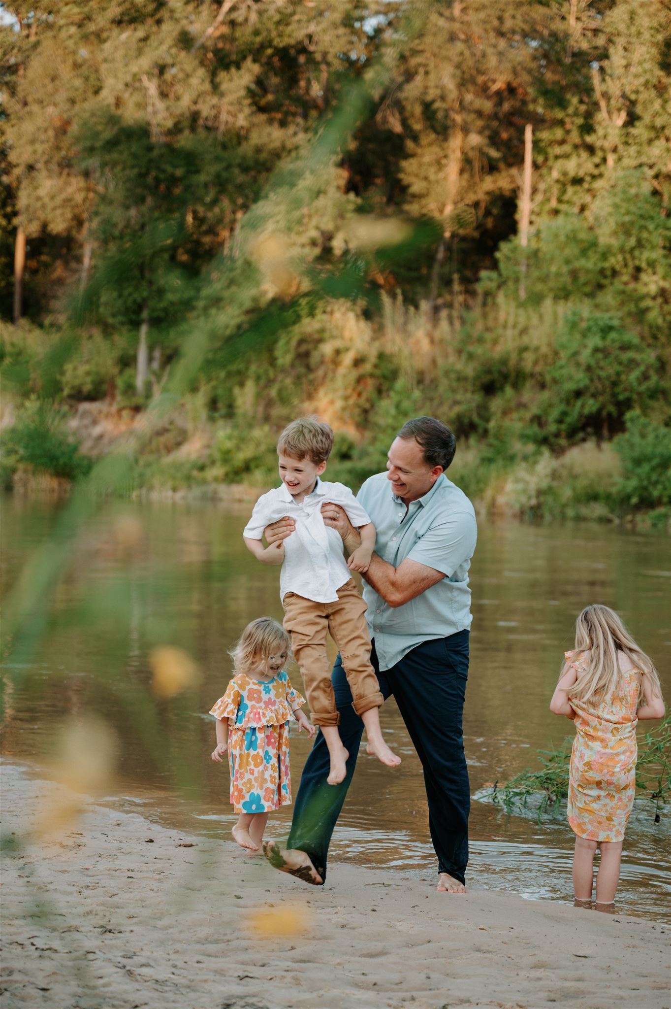 A playful moment at the riverside with children in summer attire.