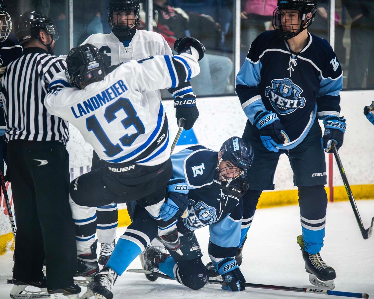 Hockey players scramble for position during an intense game sequence on the ice.