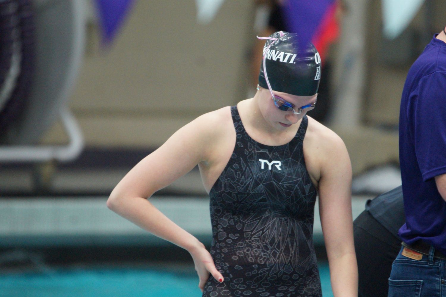 Swimmers preparing at starting blocks during competitive swimming meet.
