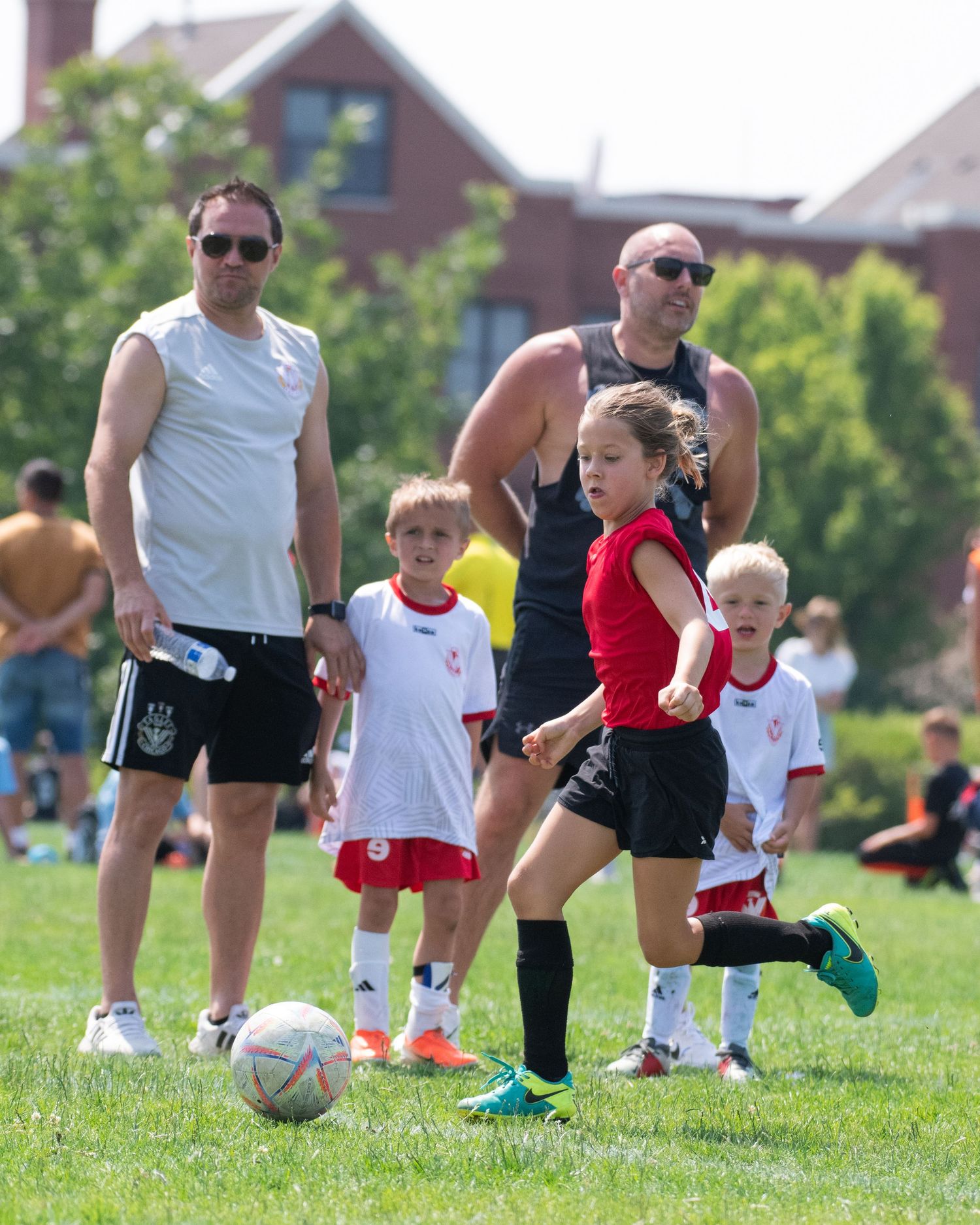 Young soccer players practicing ball control drills on a green field.