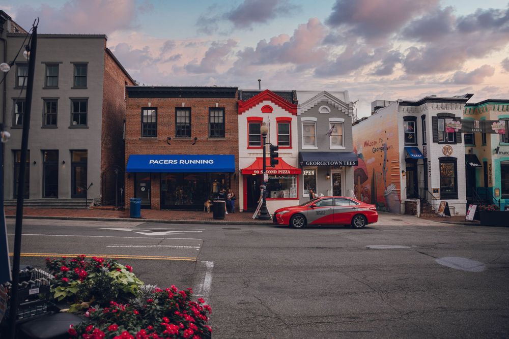 Charming small town main street with colorful buildings and red car during sunset.