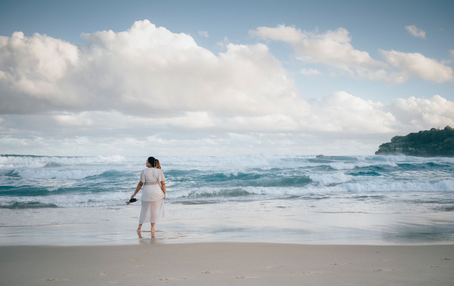 A lady standing on Bondi Beach seashore