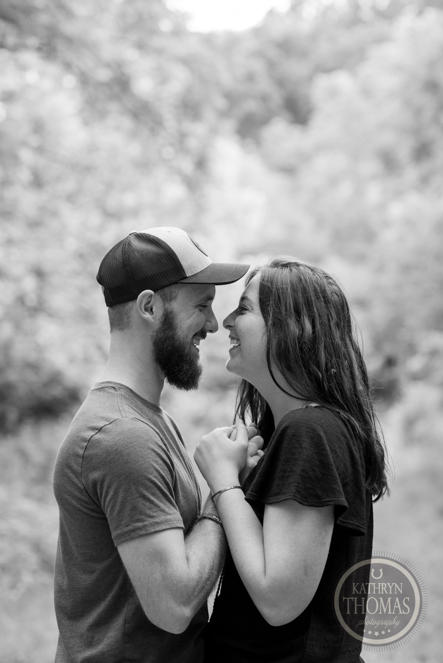 An intimate black and white portrait of a couple sharing a tender moment.