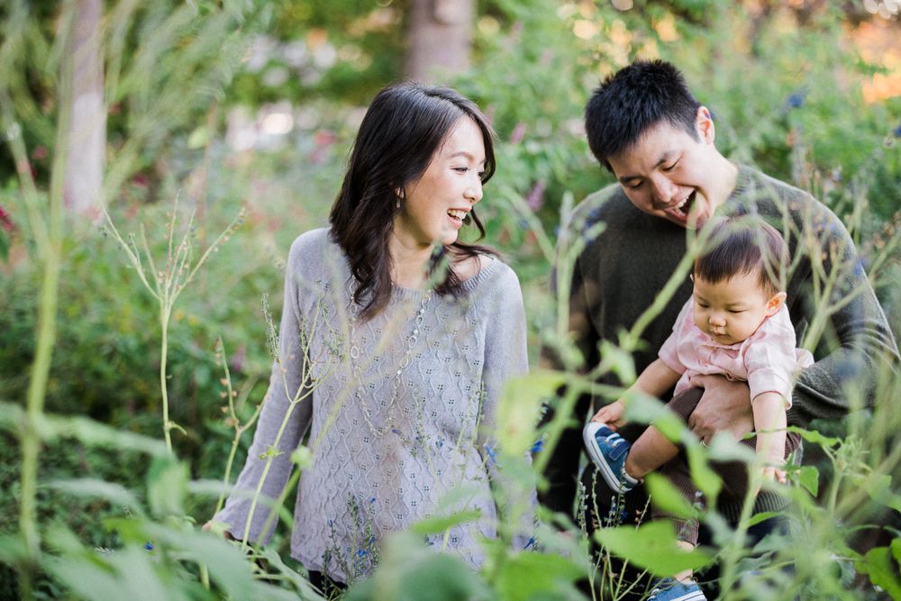 A candid family scene amid natural greenery and garden foliage.