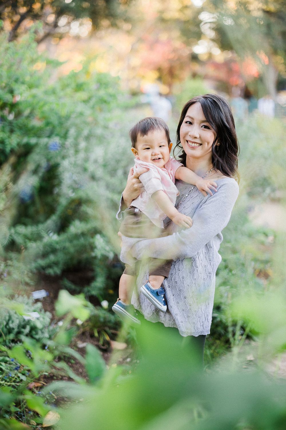 Sweet candid moment captured between parent and child in a lush garden setting.