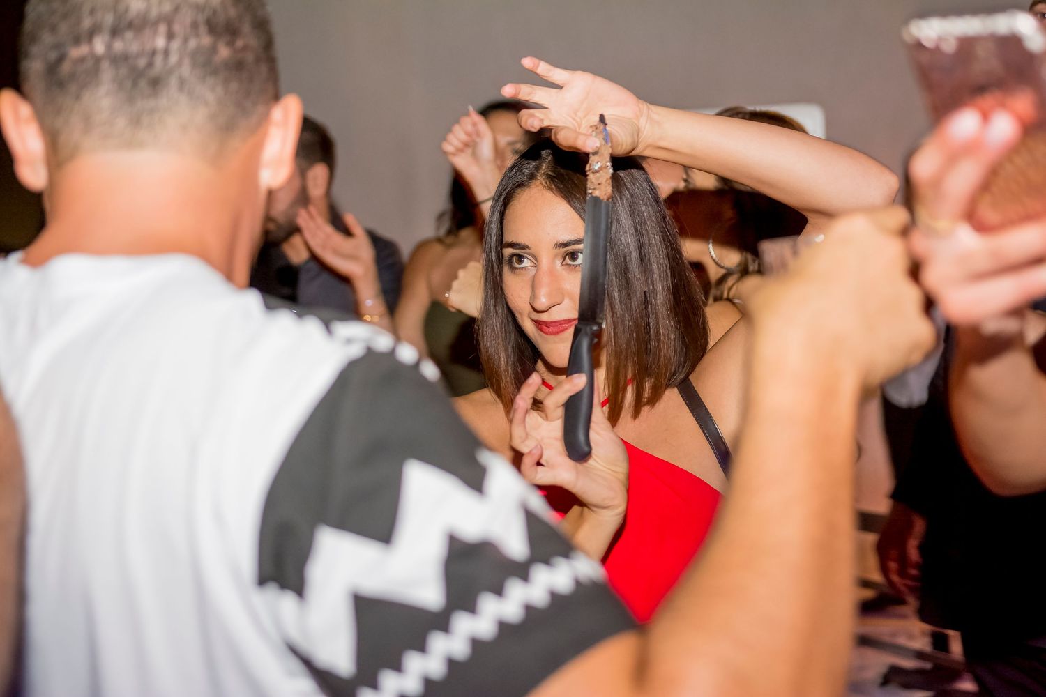 Lively dance party with people dancing and raising their hands in celebration.