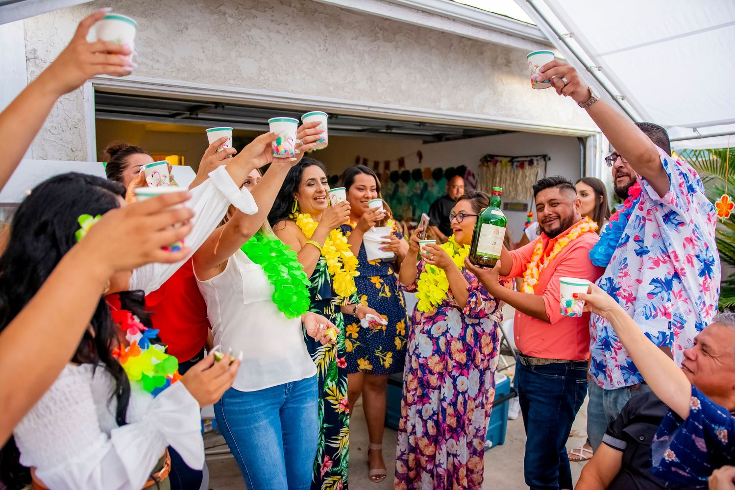 Festive party scene with people celebrating and holding colorful drinks.