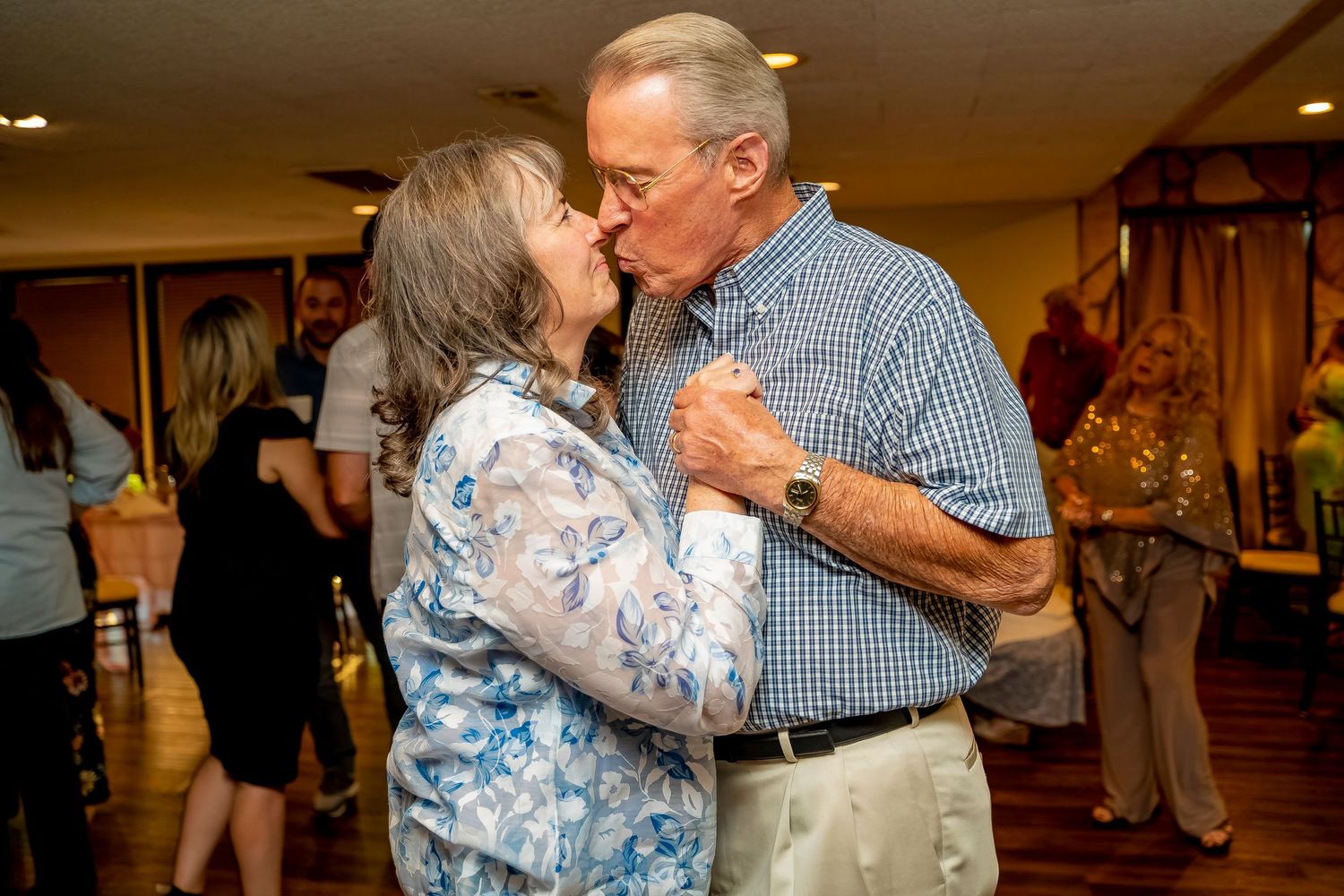 Couple sharing an intimate dance moment at a social gathering.