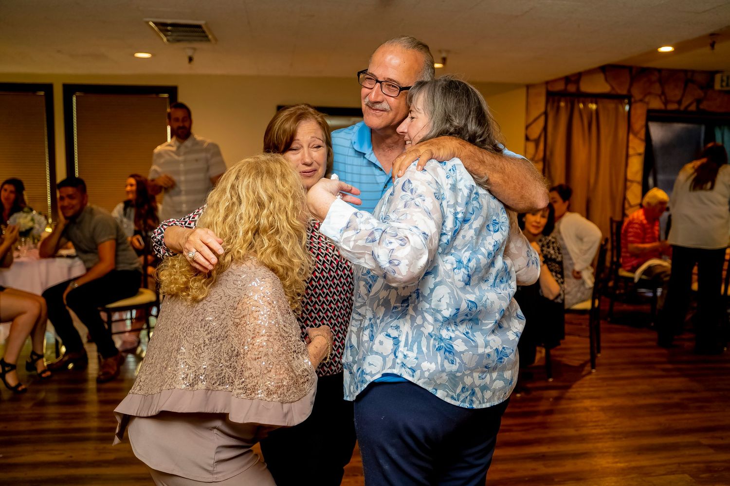 Dancing couples enjoying themselves at a lively social gathering in a wooden-floored venue.
