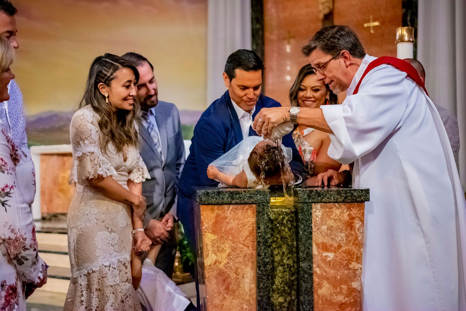 Religious baptism ceremony taking place at ornate church altar.