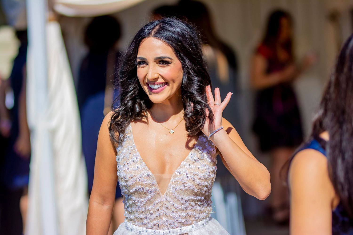 Sparkling beaded dress at a celebration with white drapes in background.