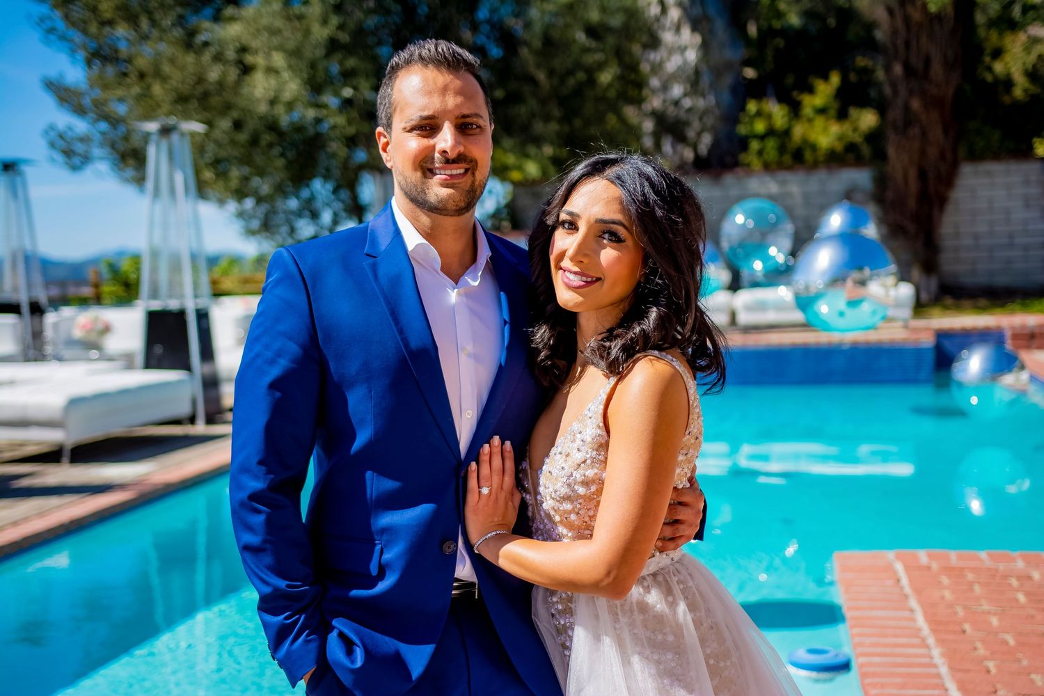 Outdoor poolside celebration with blue and white balloon decorations.