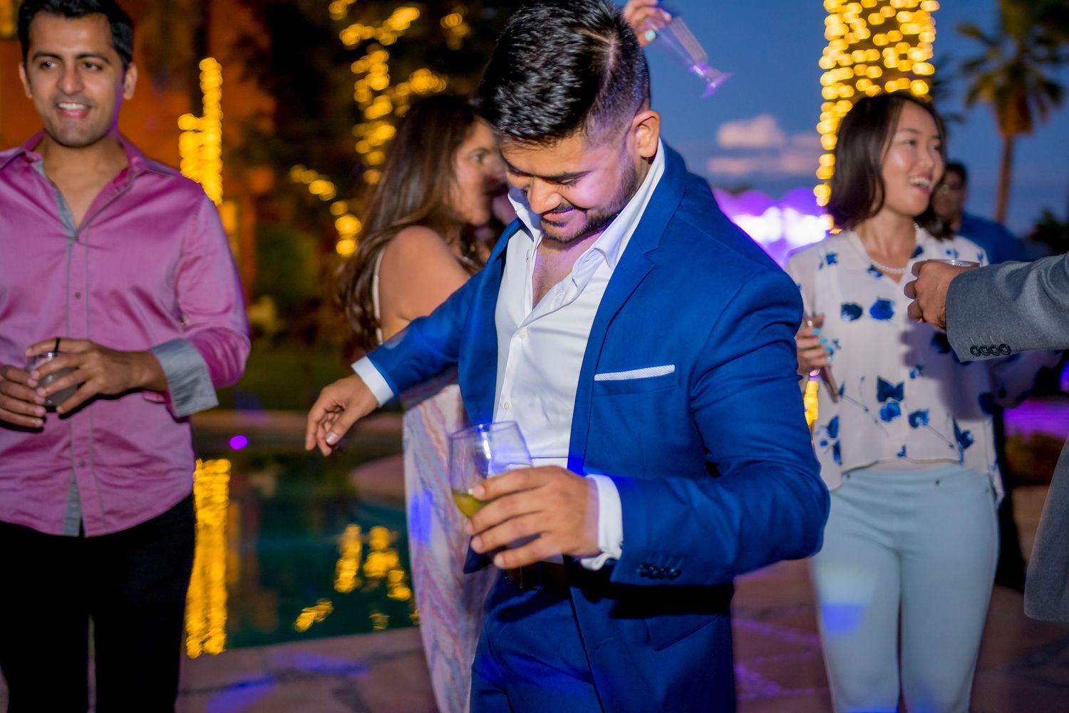 People dancing and celebrating at an outdoor evening party.