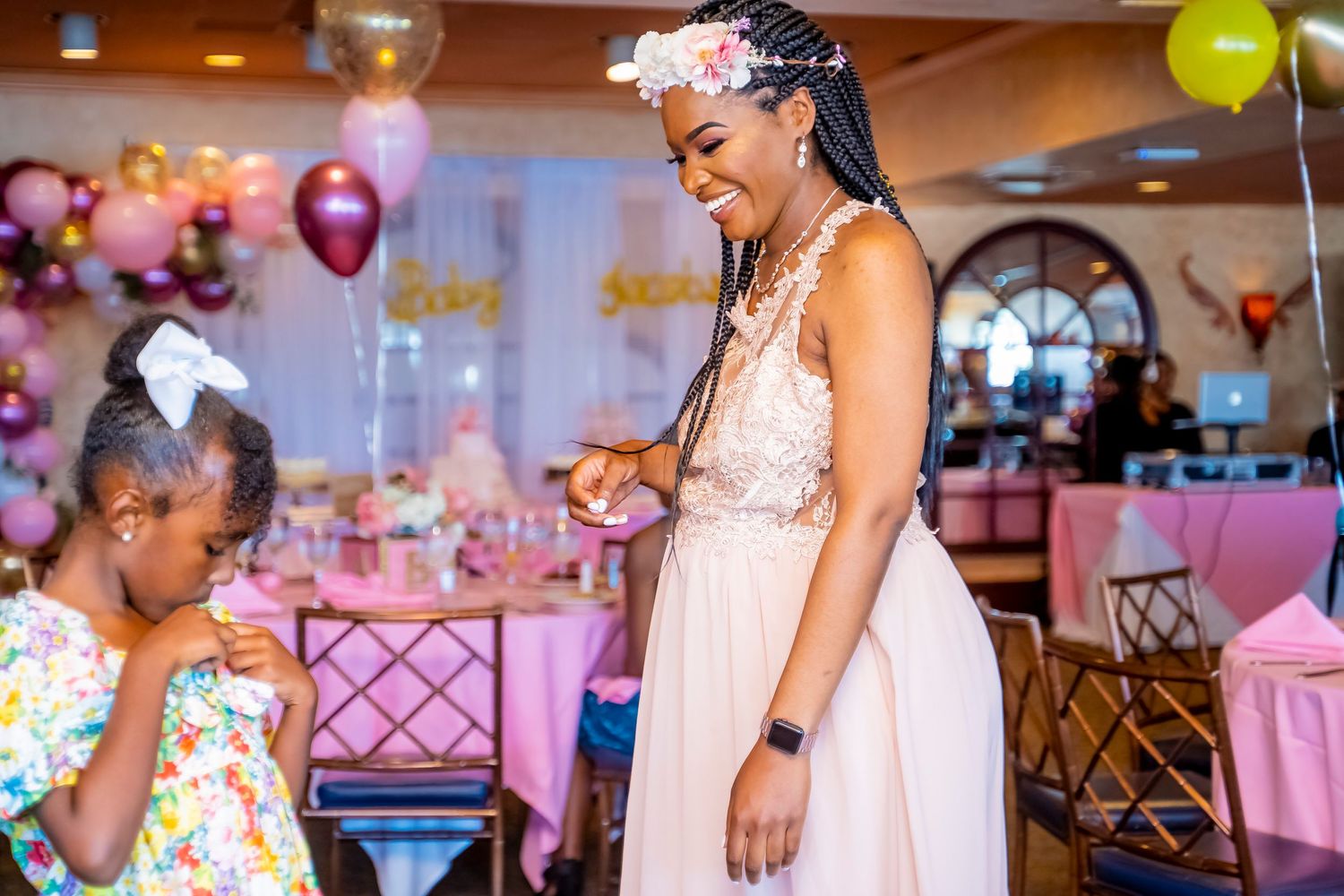 An elegant celebration with pink decor and balloons at a formal party venue.