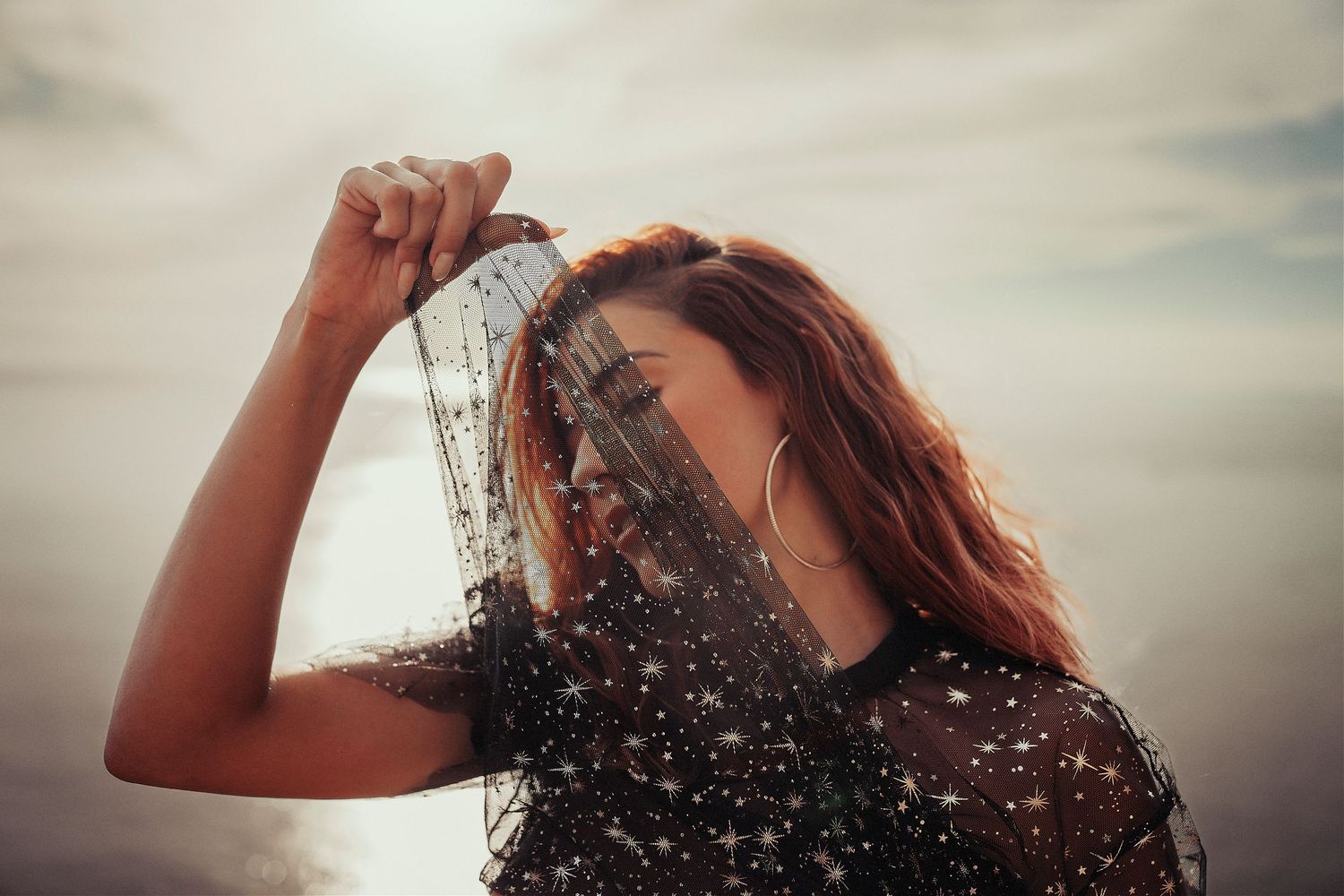 Water droplets splash through sunlit air in an artistic portrait shot.