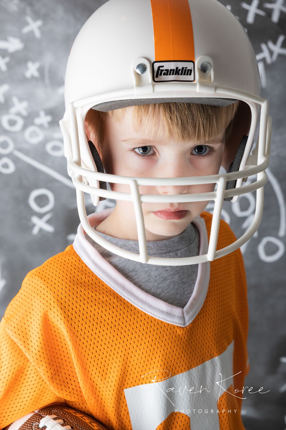 Boy in University of Tennessee jersey and helmet for football photo session