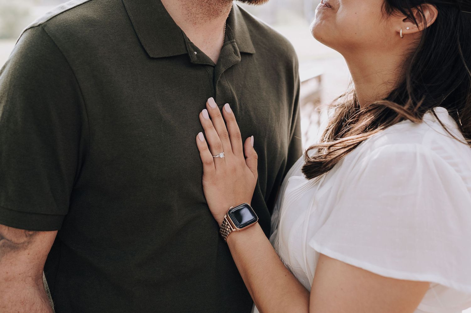 A close-up shot of a couple in casual attire sharing an intimate moment outdoors.