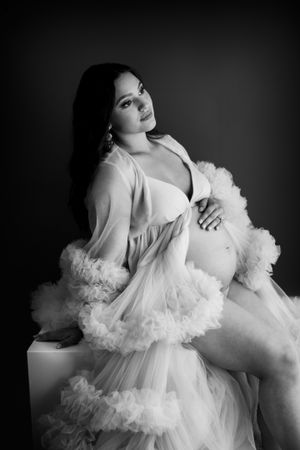 Classic black and white maternity portrait with flowing tulle robe.