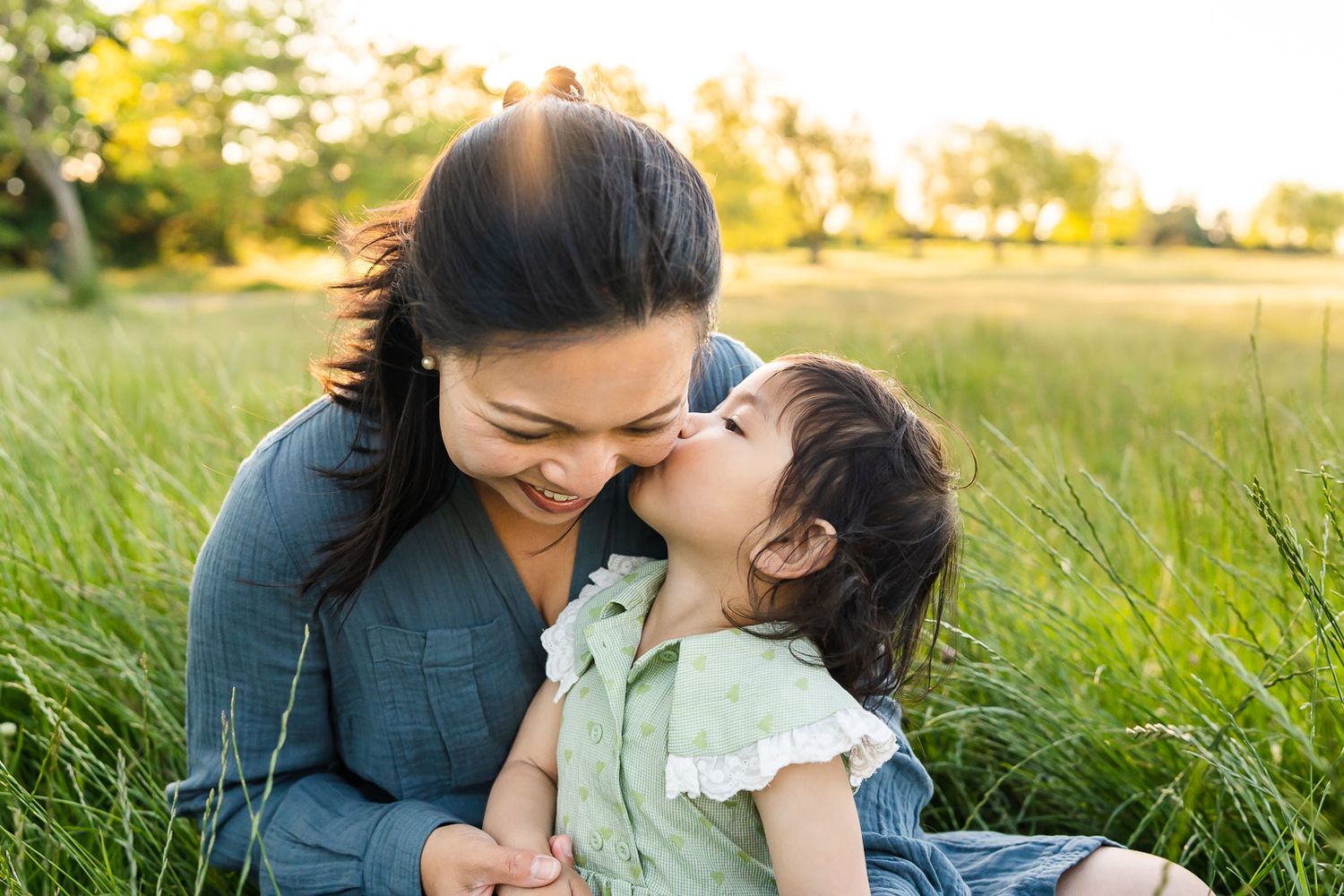Daughter kisses mother at family photos