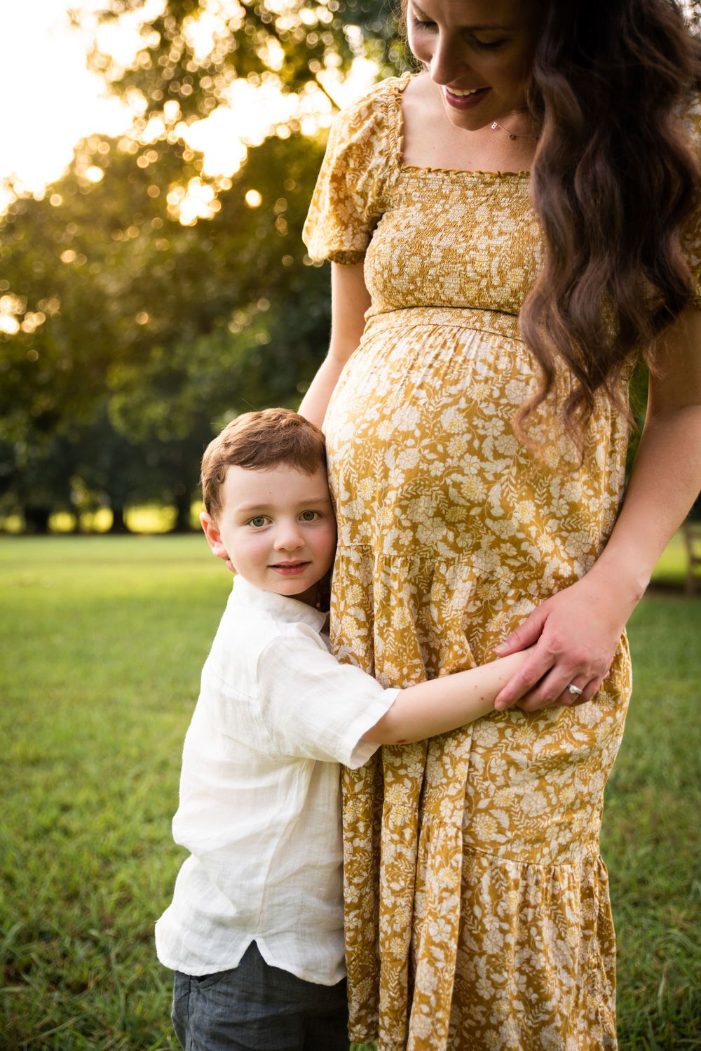 A boy hugging his mom's pregnant belly