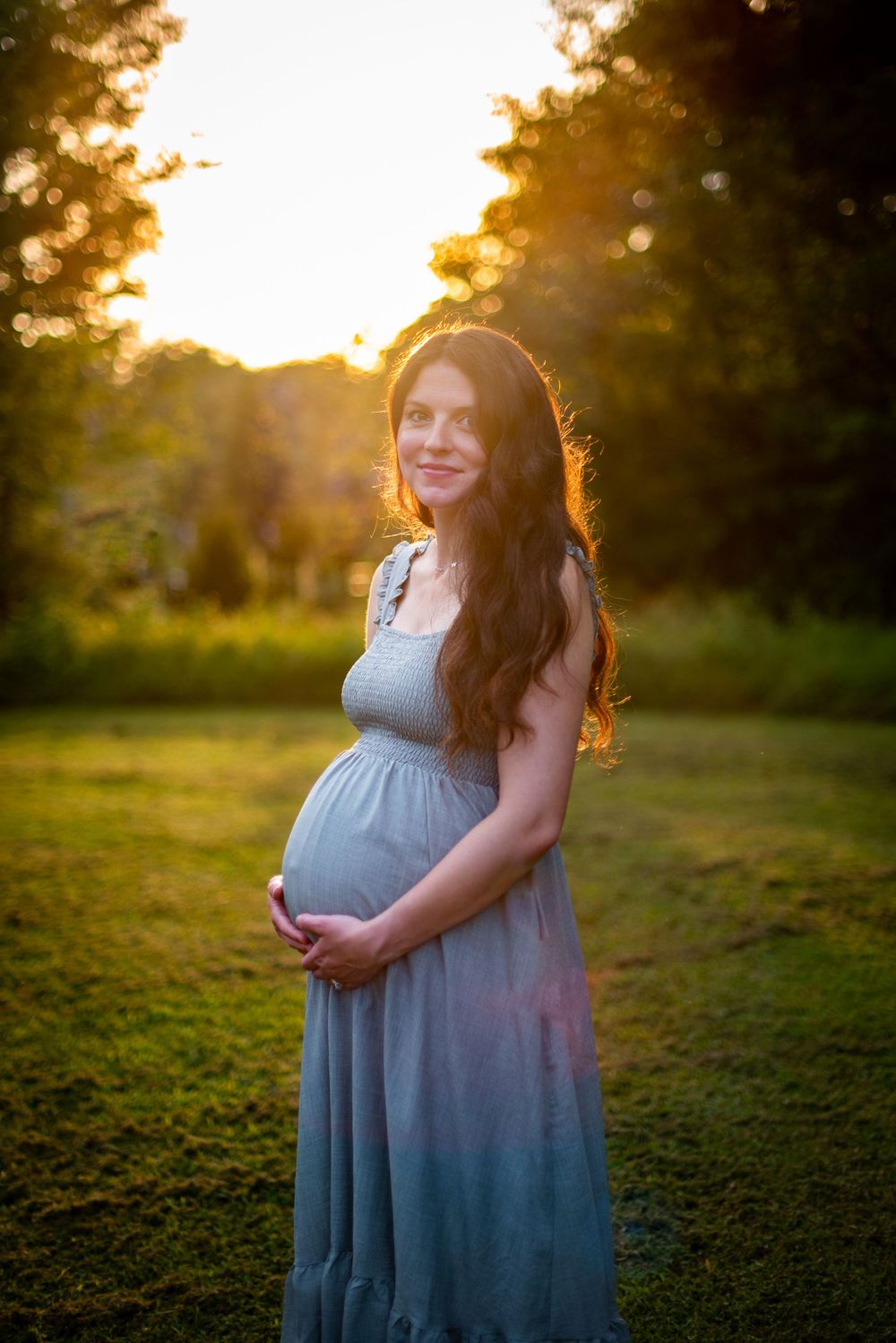 Pregnant women in a field with the sunset