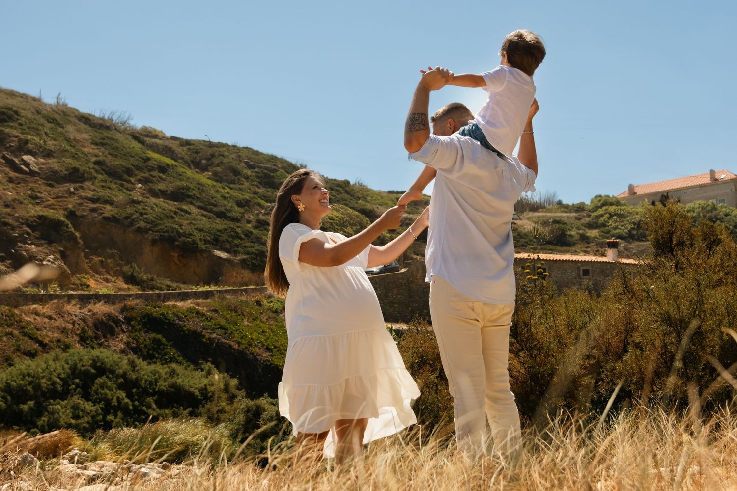 Group in white clothing walking together on hilltop trail against blue sky.