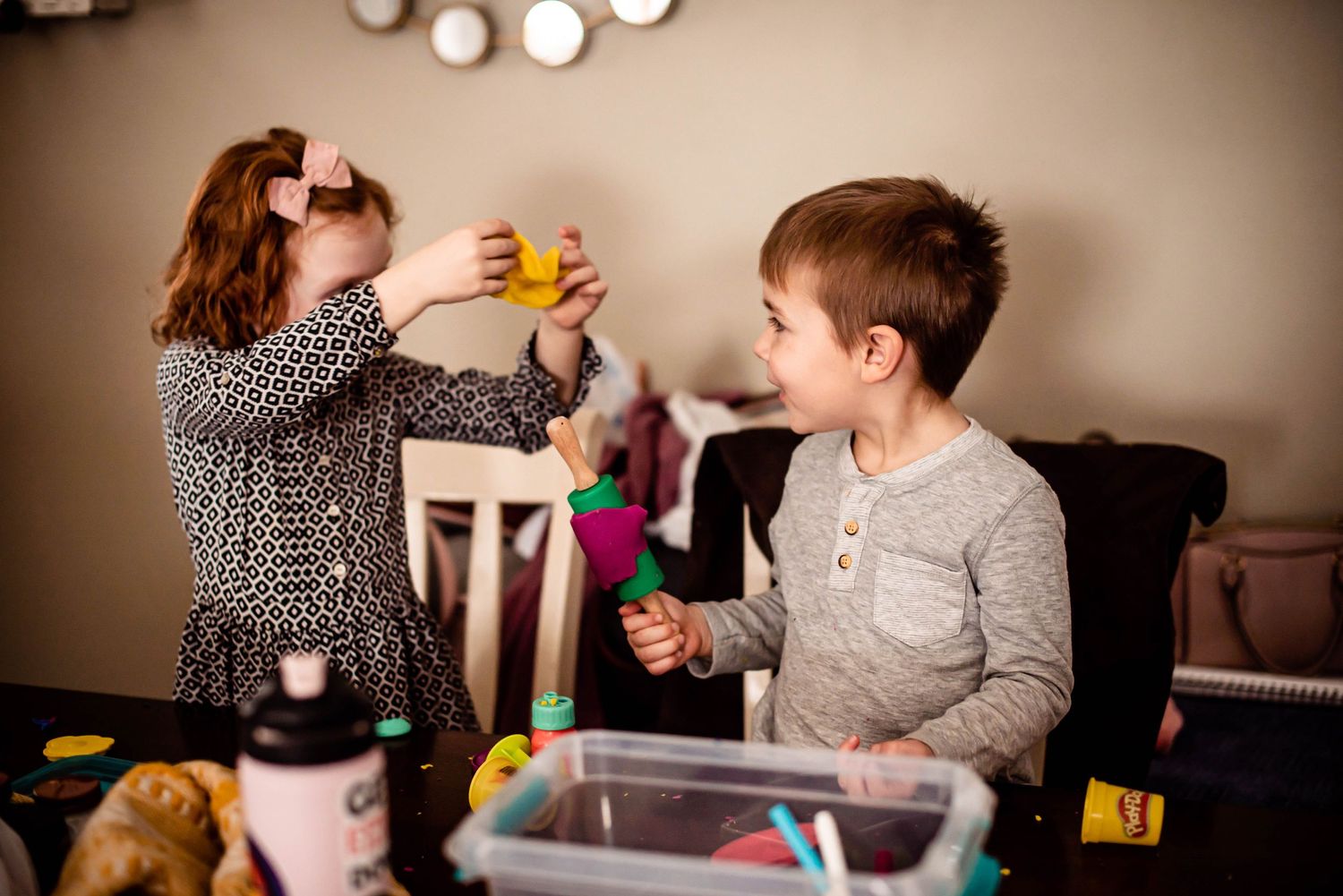 Children engaged in a playful activity with colorful toys at a table.
