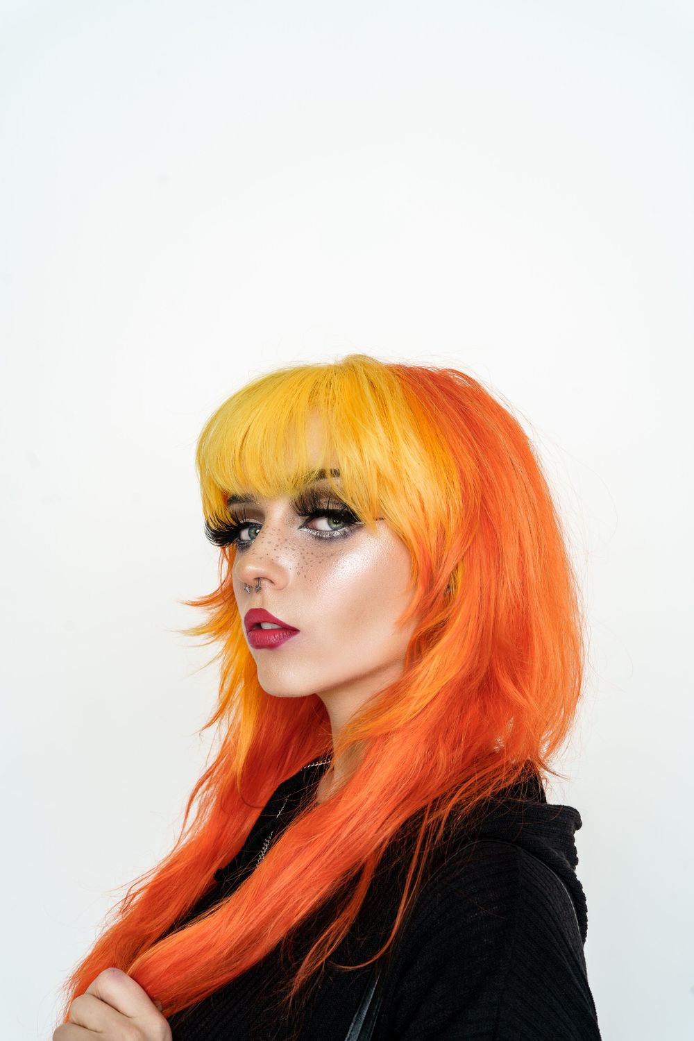 Artistic portrait series showing woman with vibrant orange and yellow hair against white background.
