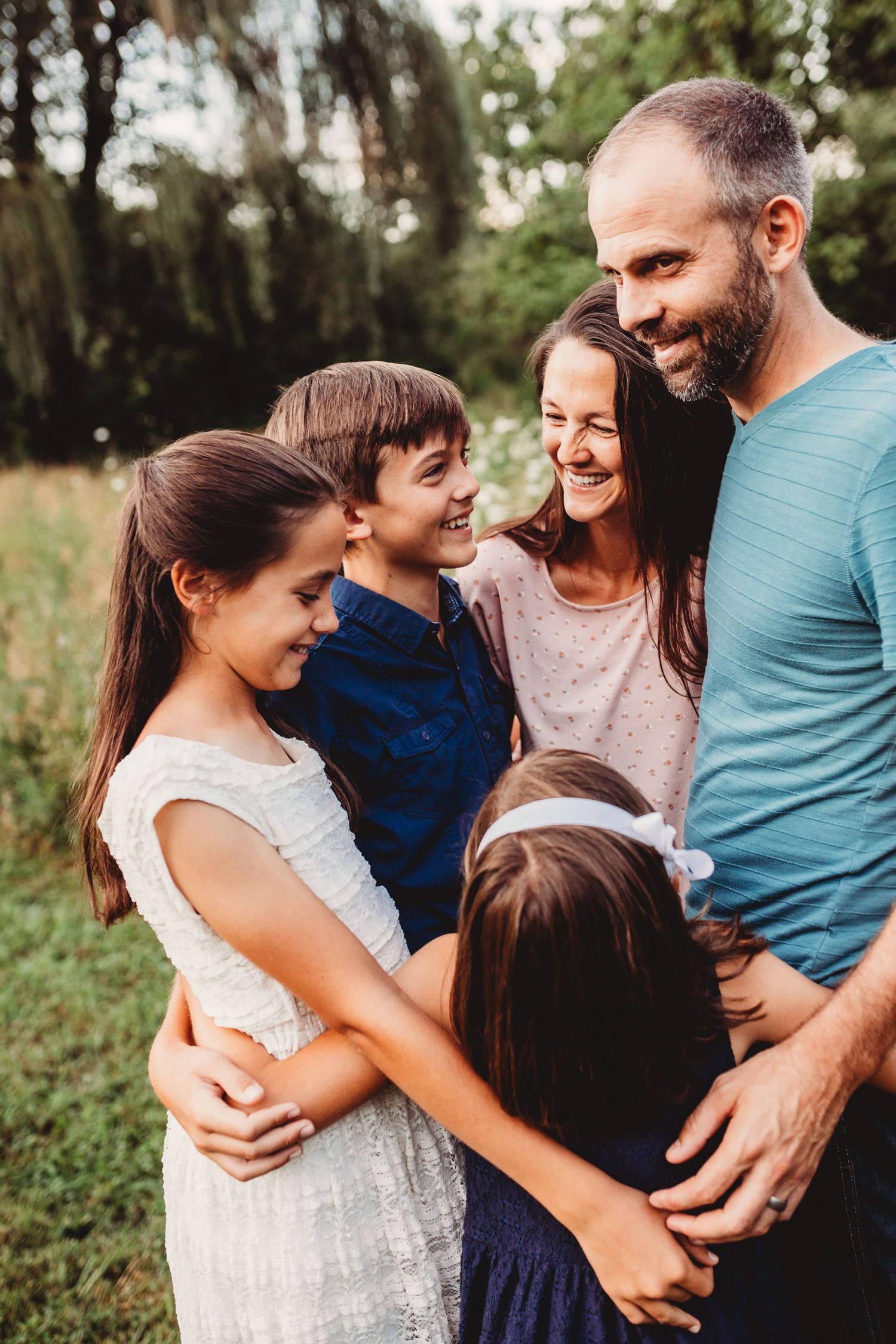 Candid family group hug in the woods