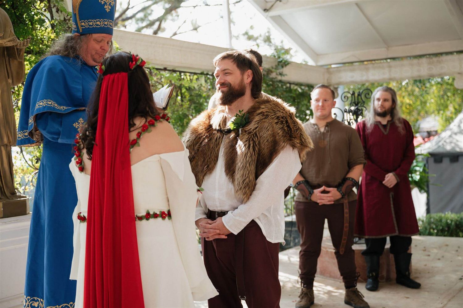 Medieval-themed wedding ceremony with participants in period costumes.