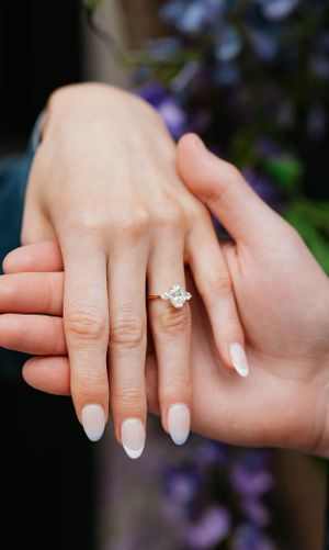 Close-up of an elegant oval diamond solitaire engagement ring on a woman's hand.